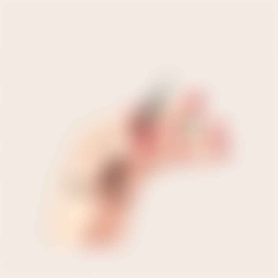 A dotting tool creating polka dots on an almond shaped nail
